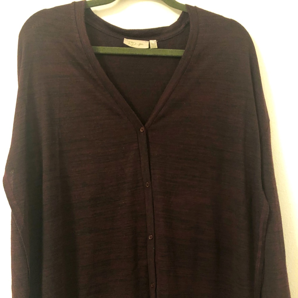 Sweater buttons up the front + opens on both sides